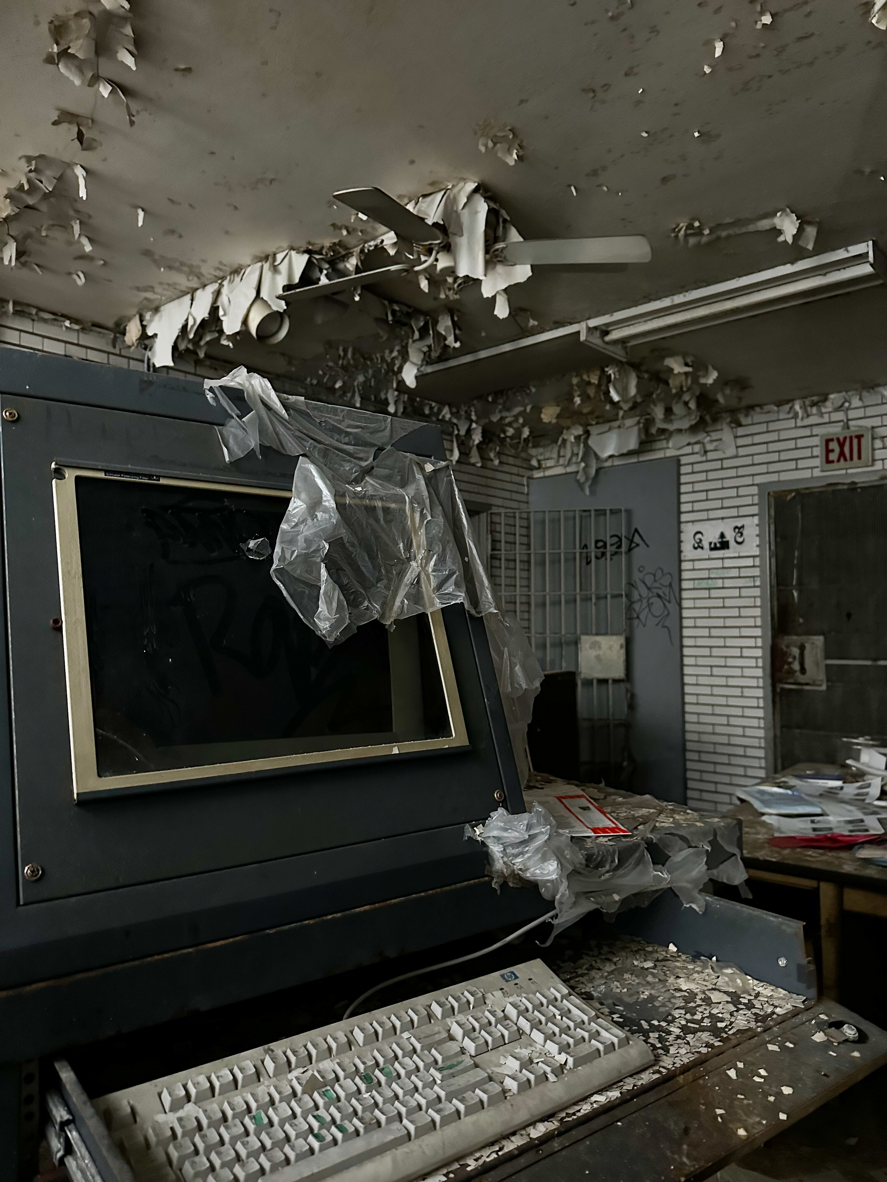 Dusty computer and peeling paint in an abandoned police station